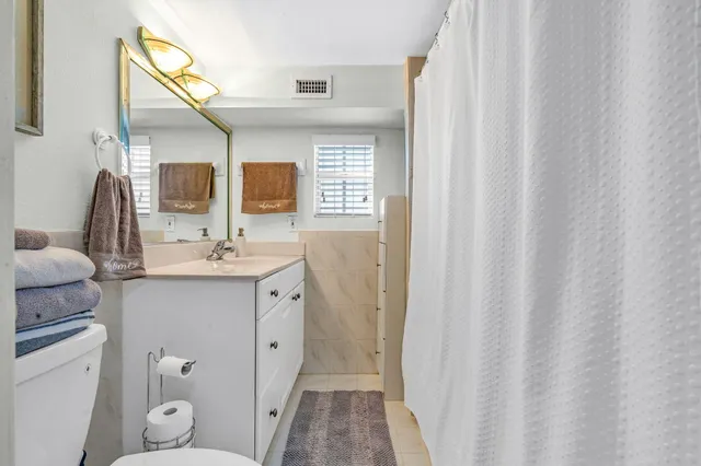 a bathroom with a sink a toilet and a mirror