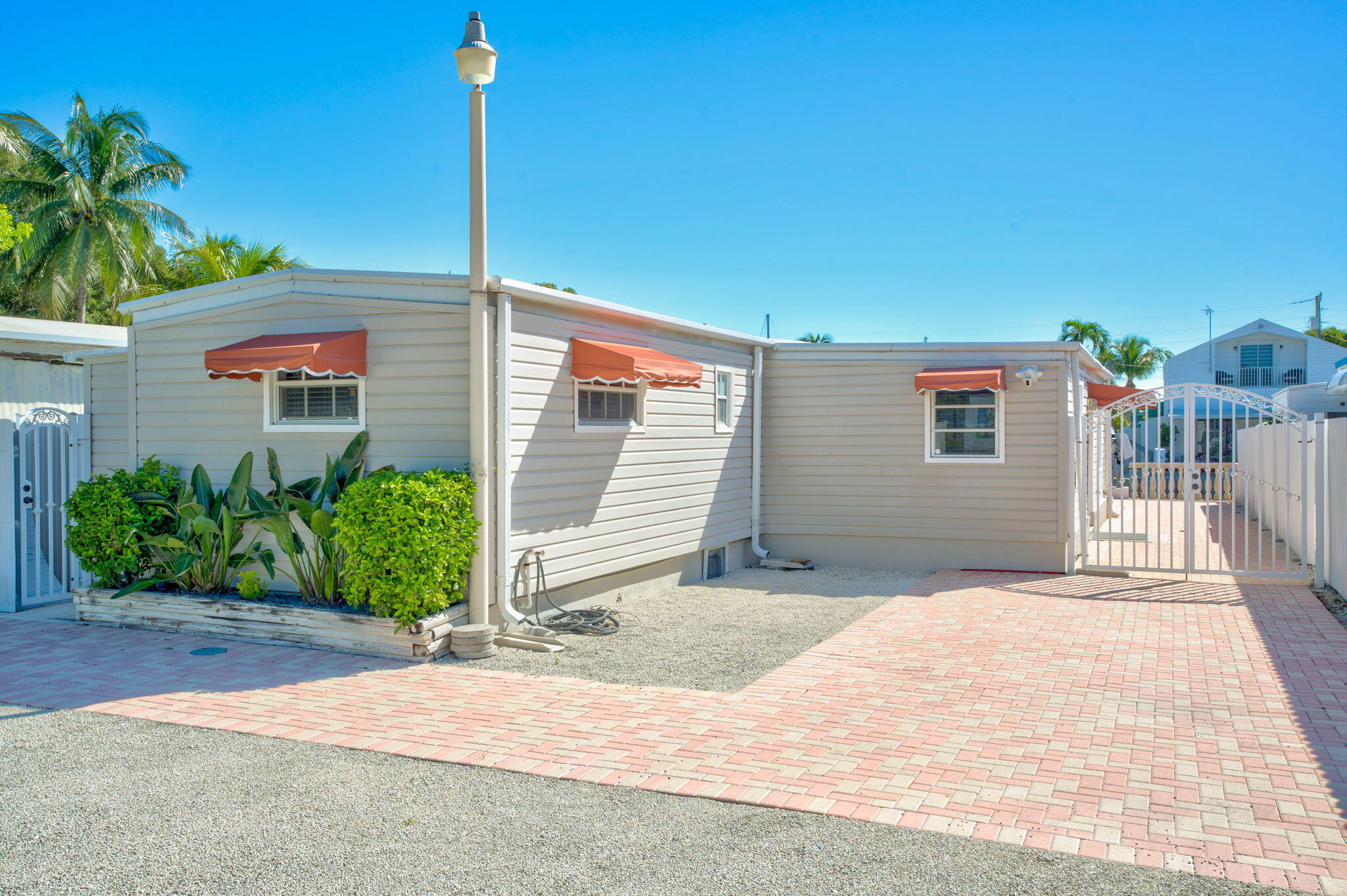 136 Sable Palm Lane Tavernier, FL 33070 - Photo 21 of 39 a front view of a house with a yard and potted plants