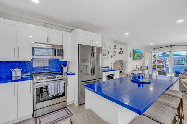 a kitchen with stainless steel appliances granite countertop a sink refrigerator and cabinets