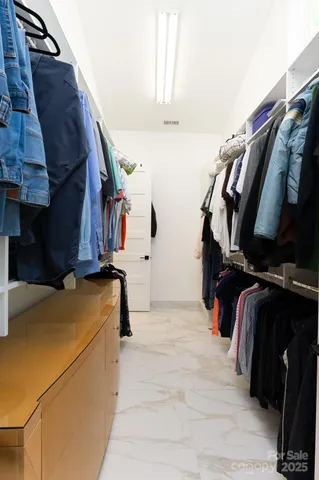 a view of walk in closet with clothes and shoes