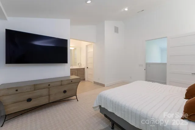 a bedroom with a bed and a flat screen tv