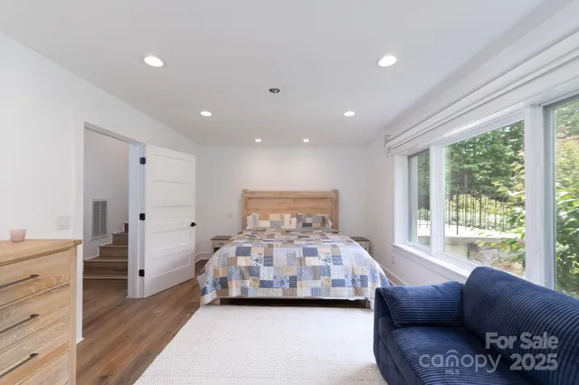 a large bedroom with a bed and a large window