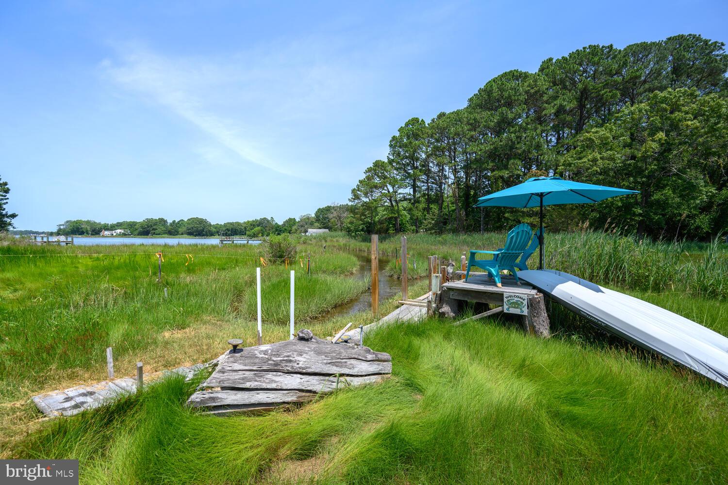8000 Bozman Neavitt Road St. Michaels, MD 21663 - Photo 11 of 57 a view of a lake with a table and chairs under an umbrella