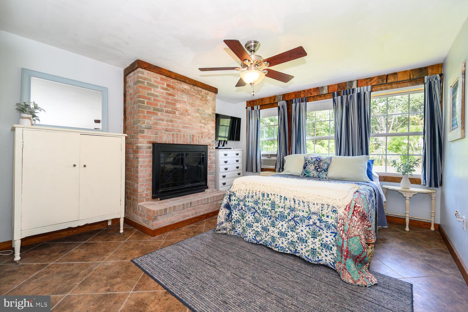 8000 Bozman Neavitt Road St. Michaels, MD 21663 - Photo 35 of 57 a bedroom with a bed and a fireplace