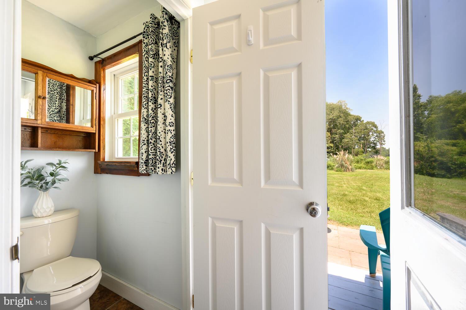 8000 Bozman Neavitt Road St. Michaels, MD 21663 - Photo 41 of 57 a bathroom with a toilet a sink and a large mirror