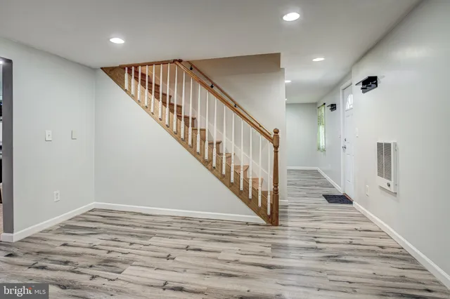 a view of a hallway with wooden floor and staircase