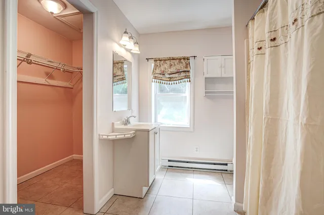 a bathroom with a granite countertop sink a mirror and a shower