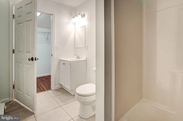 a bathroom with a granite countertop shower a toilet and a sink