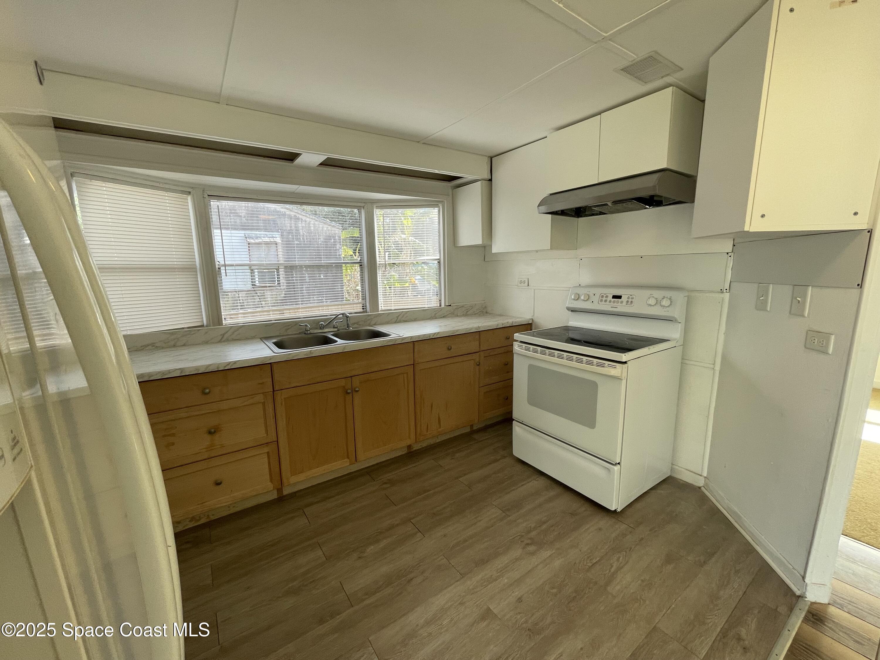 7002 Ash Drive Cocoa, FL 32927 - Photo 6 of 17 a kitchen with sink a microwave and cabinets