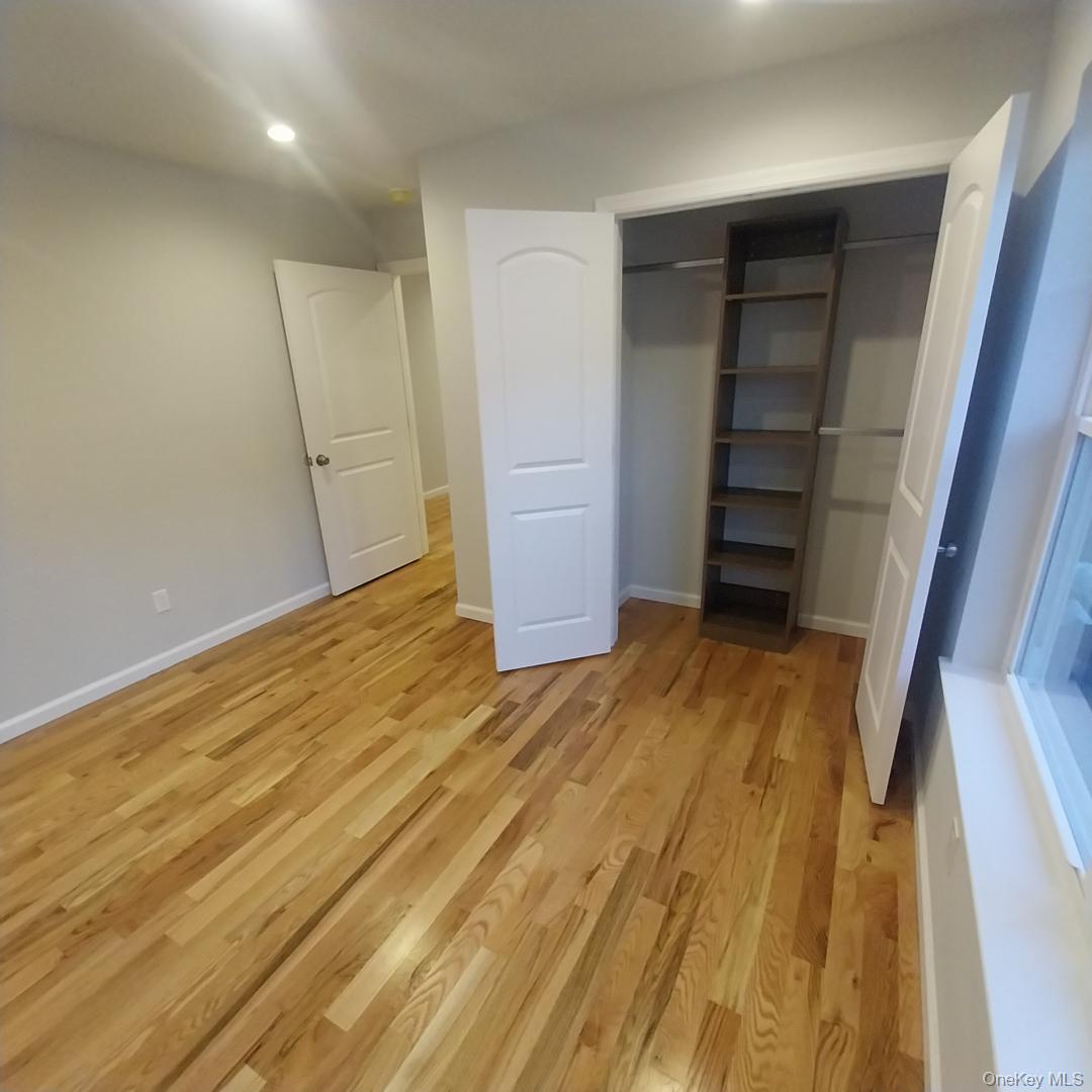 343 Jackson Street, Unit 5 Hempstead, NY 11550 - Photo 15 of 16 Unfurnished bedroom featuring light wood-type flooring, a closet, and recessed lighting