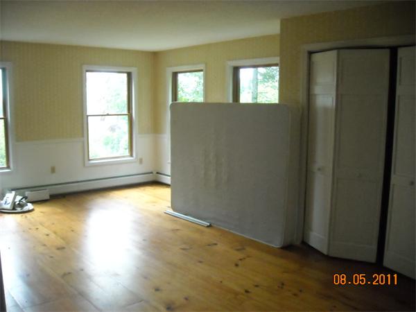 375 Kinnebrook Road Worthington, MA 01098 - Photo 10 of 12 an empty room with wooden floor and windows