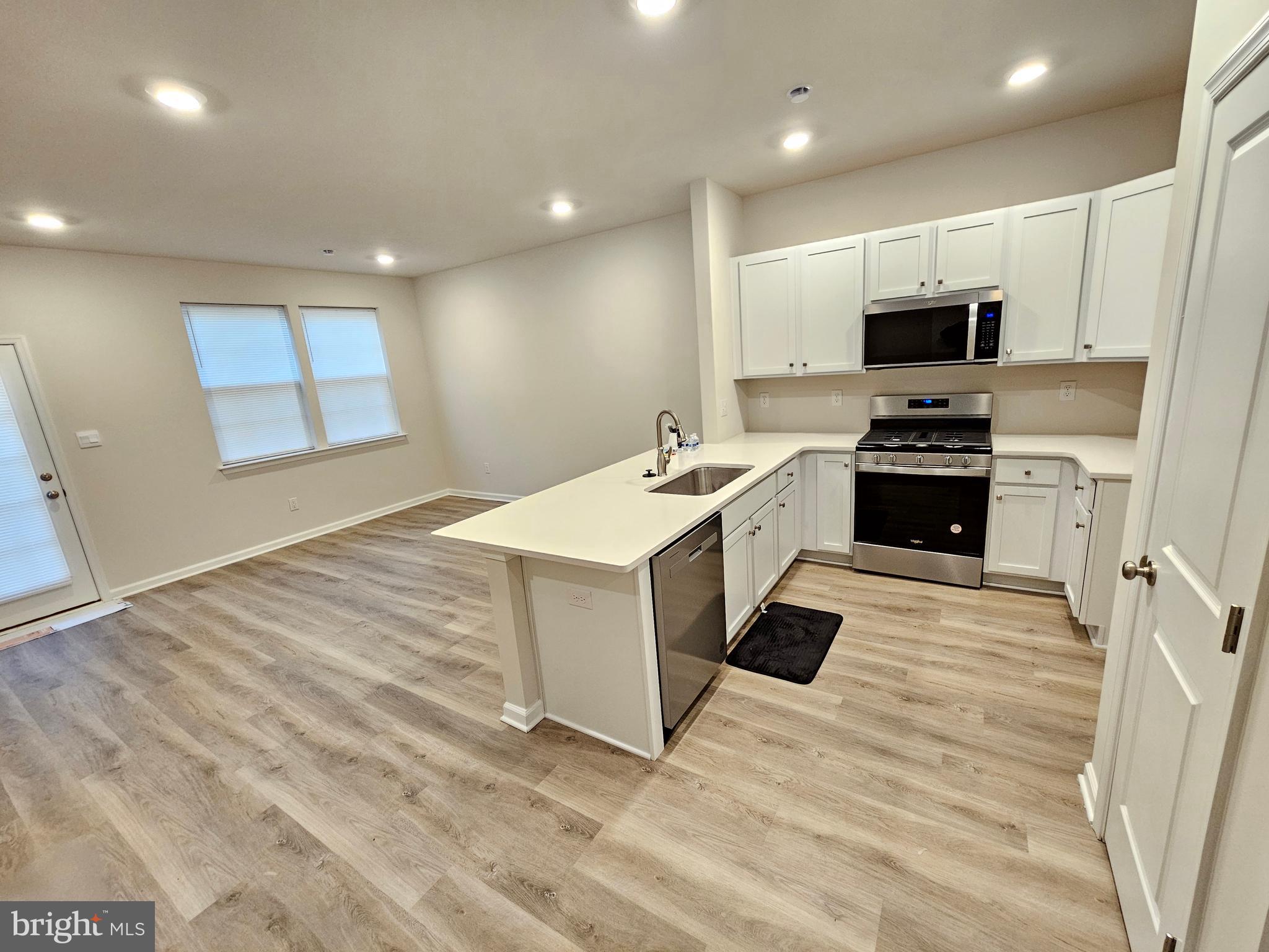 21 Alexander Way Westampton, NJ 08060 - Photo 6 of 25 a kitchen with stainless steel appliances granite countertop a stove top oven a sink dishwasher and a refrigerator with wooden floor