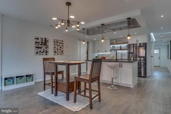 a kitchen with stainless steel appliances kitchen island granite countertop a table chairs and a refrigerator