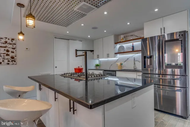 a kitchen with stainless steel appliances granite countertop a sink refrigerator and microwave