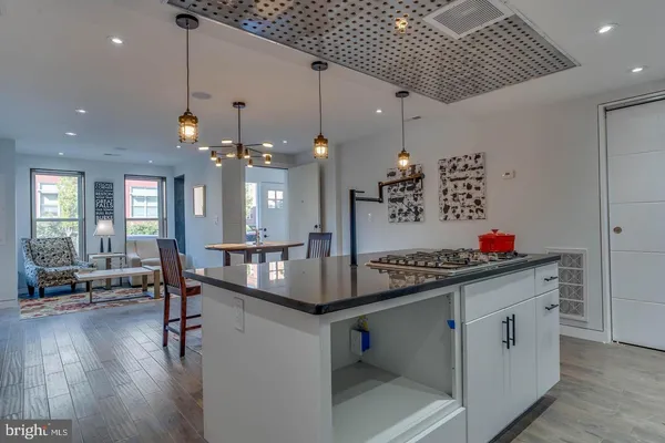 a kitchen that has a lot of cabinets a sink and wooden floor