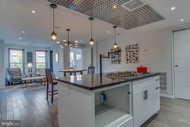 a kitchen that has a lot of cabinets a sink and wooden floor