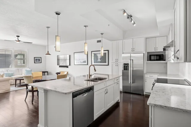 a kitchen with stainless steel appliances granite countertop a sink a stove and a refrigerator