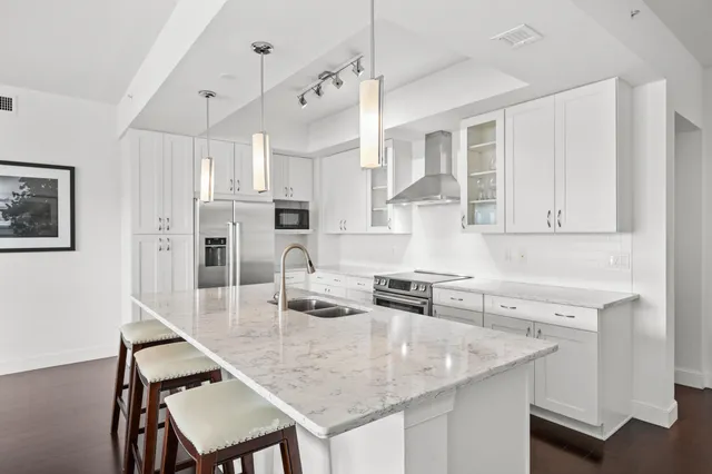 a kitchen with stainless steel appliances granite countertop a sink a stove a refrigerator a counter top space and cabinets