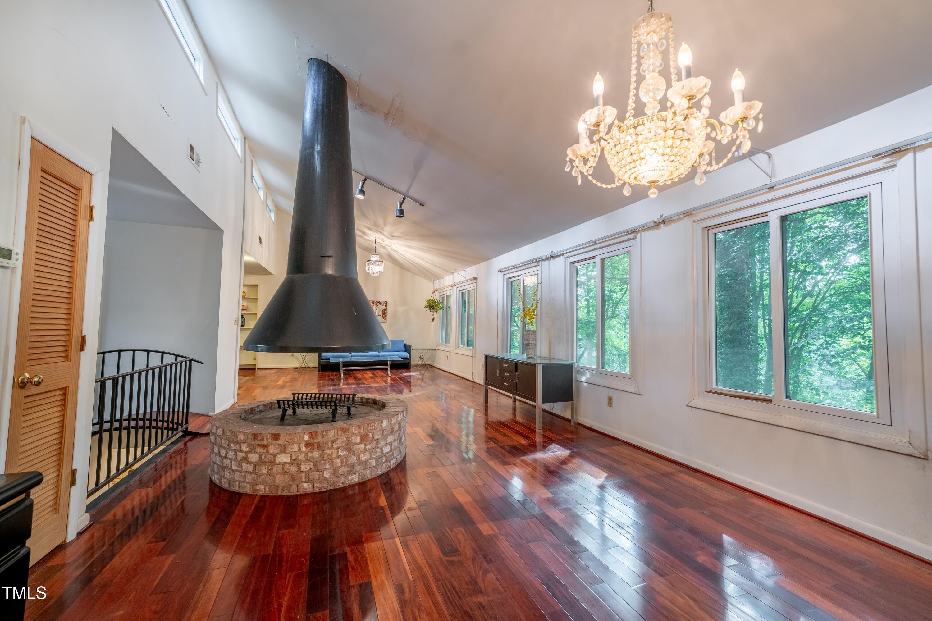 3416 Ocotea Street Raleigh, NC 27607 - Photo 15 of 46 a dining room with furniture a chandelier and wooden floor