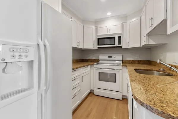 a kitchen with stainless steel appliances granite countertop a stove a sink and a refrigerator