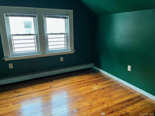 a view of a room with wooden floor and windows