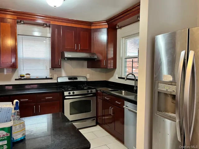 a kitchen with stainless steel appliances granite countertop a refrigerator and a stove