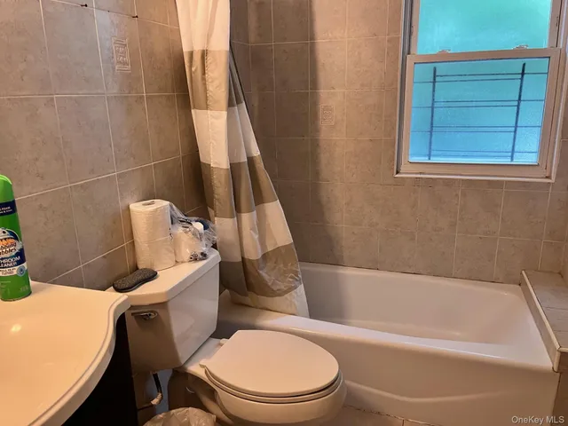 a white toilet sitting next to a bath tub