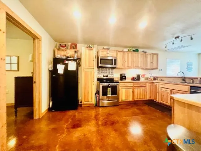 a kitchen with stainless steel appliances granite countertop a refrigerator and a stove top oven