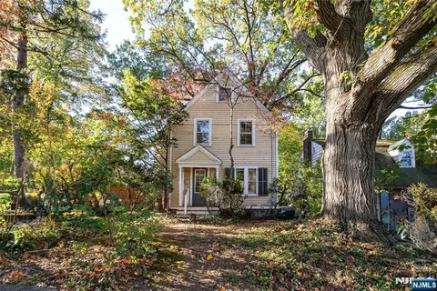 a front view of a house with yard tree and green space