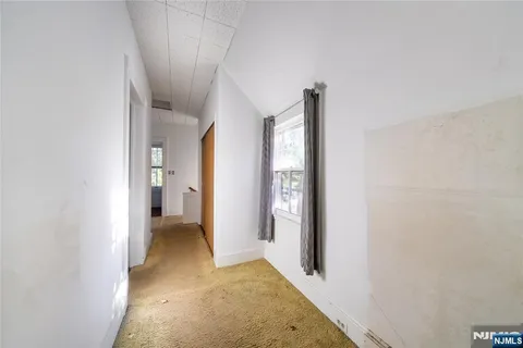 a view of a hallway with a room and a bathroom