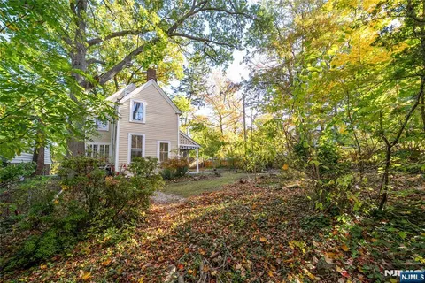 a front view of a house with a yard and trees
