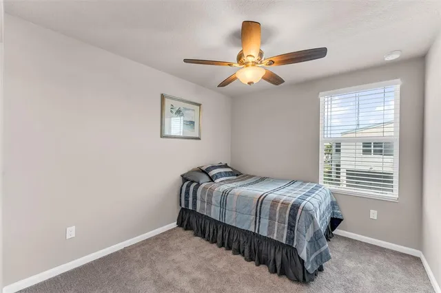 a bedroom with a bed and a ceiling fan