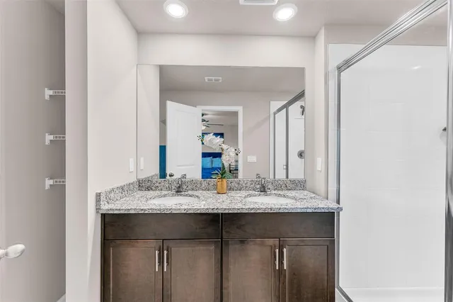 a bathroom with a granite countertop sink and a mirror