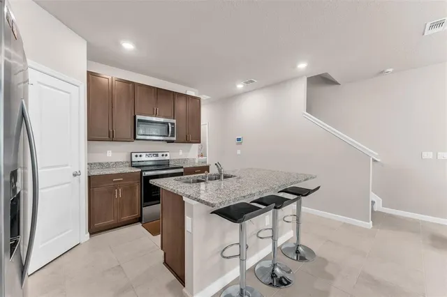 a kitchen with stainless steel appliances granite countertop a sink stove and refrigerator