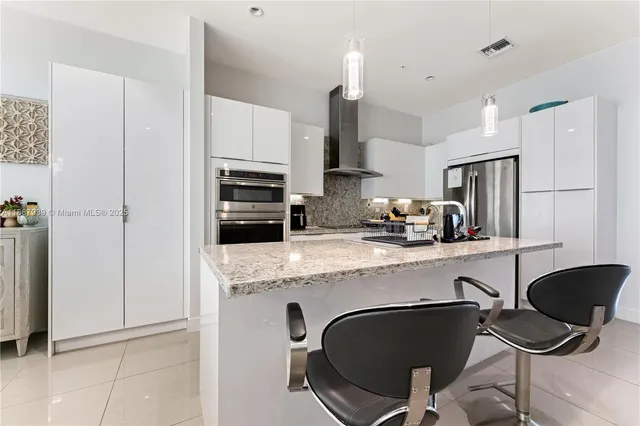 a kitchen with a dining table chairs and refrigerator
