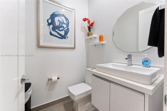 a bathroom with a sink mirror and toilet