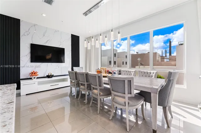 a dining room with furniture and a flat screen tv