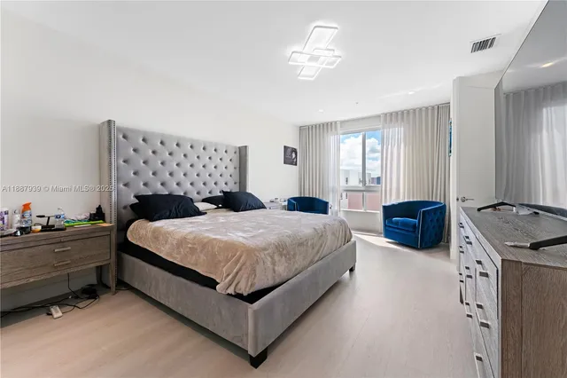 a bedroom with a bed and a chandelier