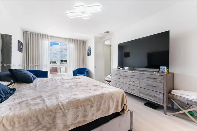 a bedroom with a bed and a flat screen tv