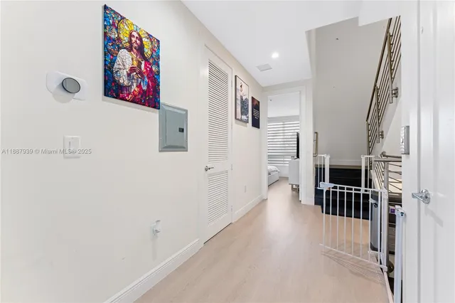 a view of a hallway with wooden floor and staircase