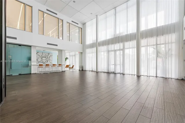 a view of a living room with hardwood floor and large windows