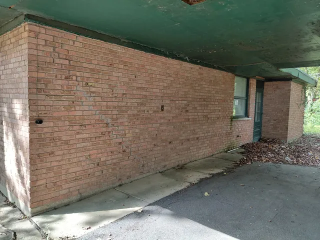a view of a brick house with a small yard