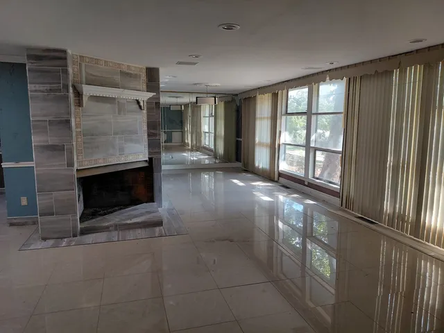 a view of an empty room with a fireplace and a window