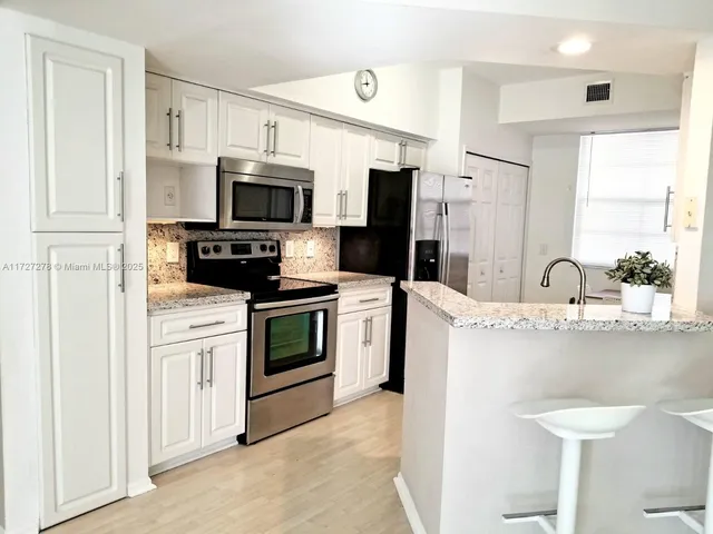 a kitchen with stainless steel appliances a stove microwave and a sink