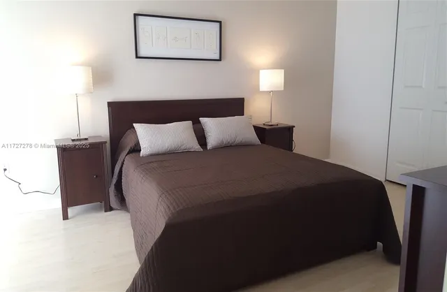 a bed sitting in a bedroom next to a lamp