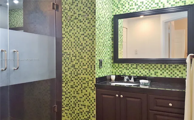 a bathroom with a sink a vanity and a shower