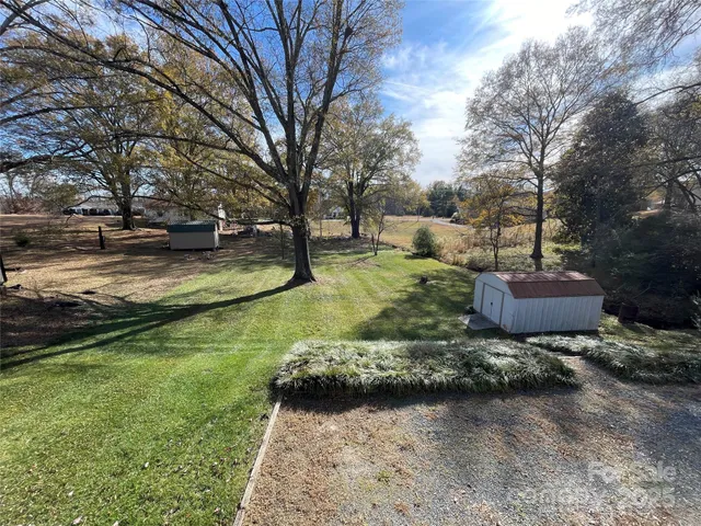 a view of a backyard with large trees