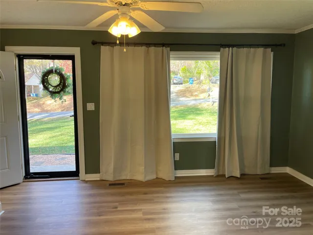 an empty room with wooden floor and windows