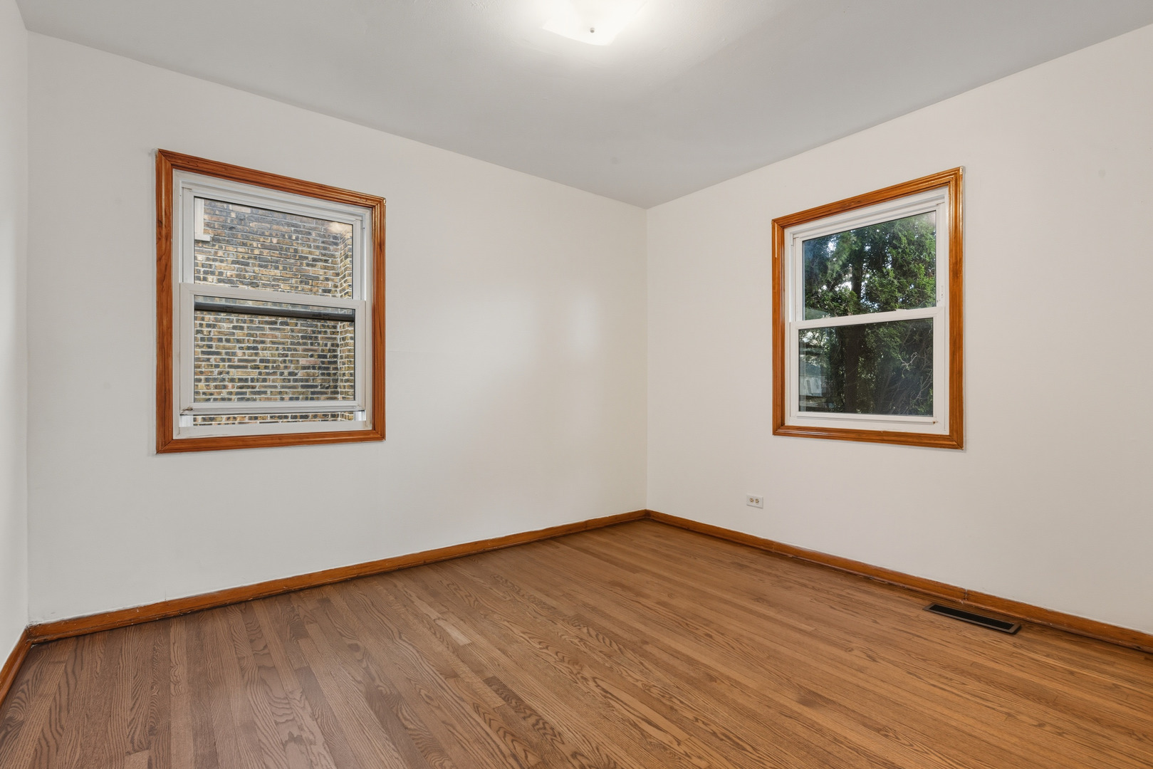 11013 Menard Avenue Chicago Ridge, IL 60415 - Photo 13 of 40 a view of an empty room with wooden floor and a window