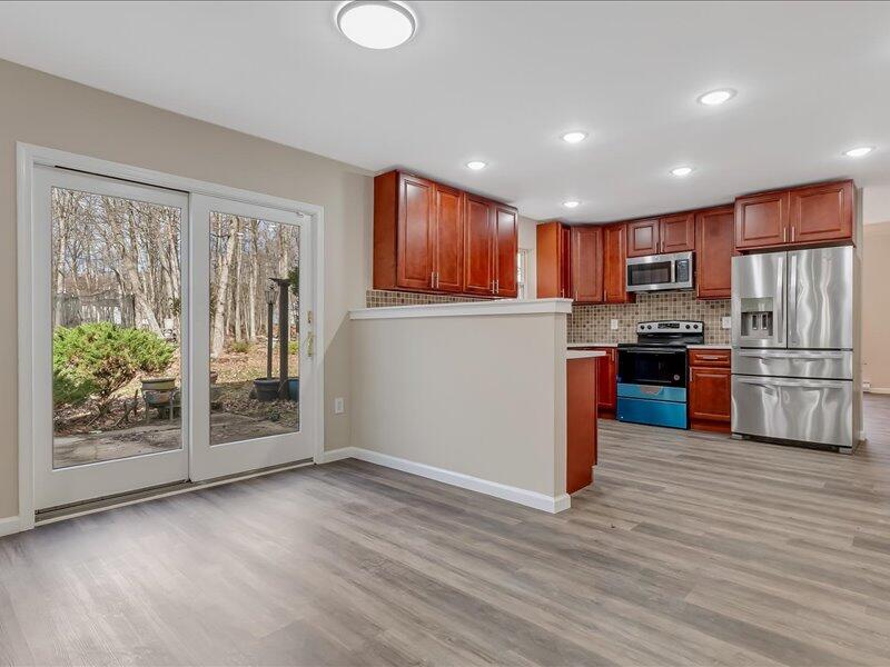 1135 Juno Drive Effort, PA 18330 - Photo 25 of 68 a kitchen with stainless steel appliances granite countertop a refrigerator oven a sink with wooden cabinets and wooden floor